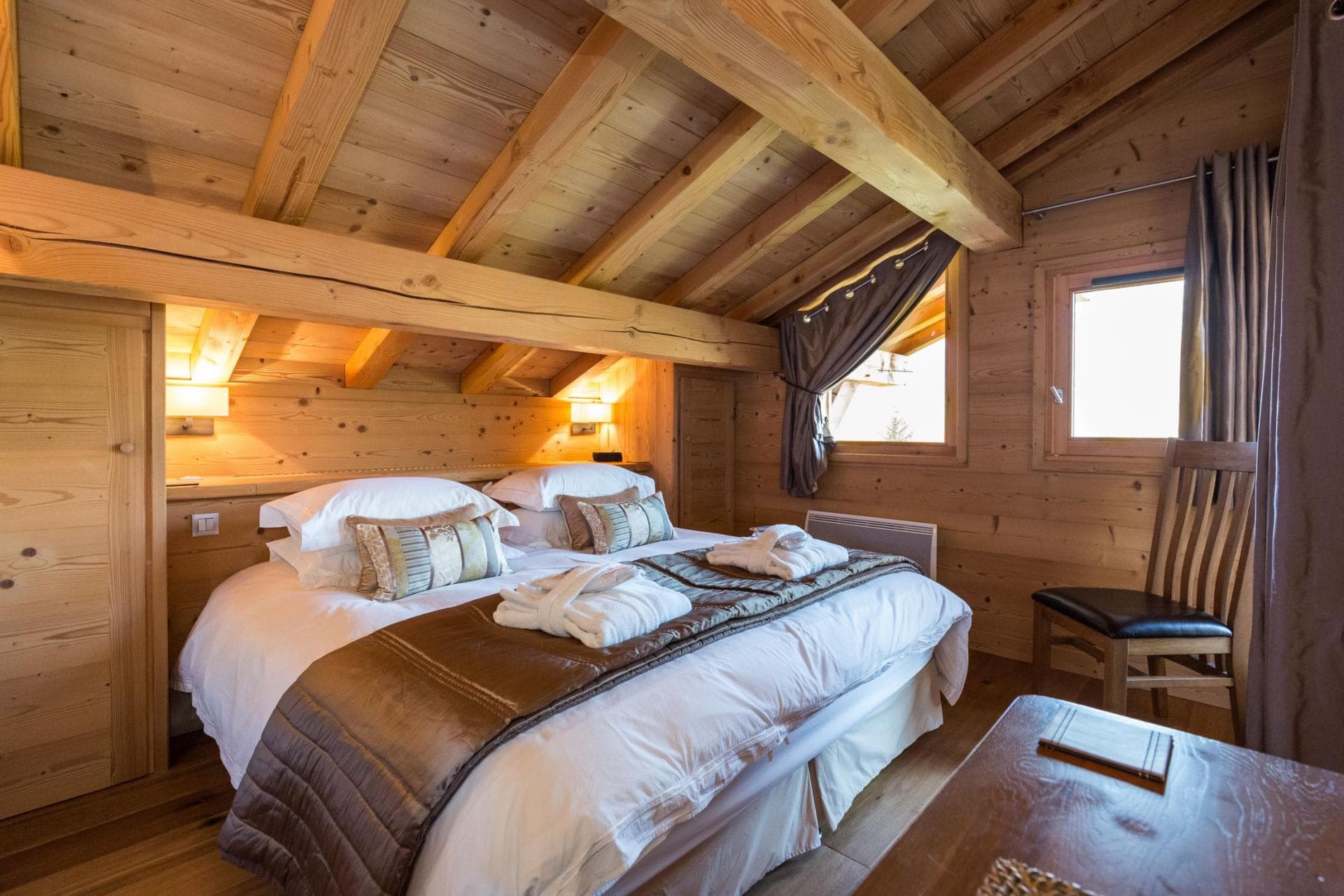 Bedroom with vaulted timber ceilings and king bed