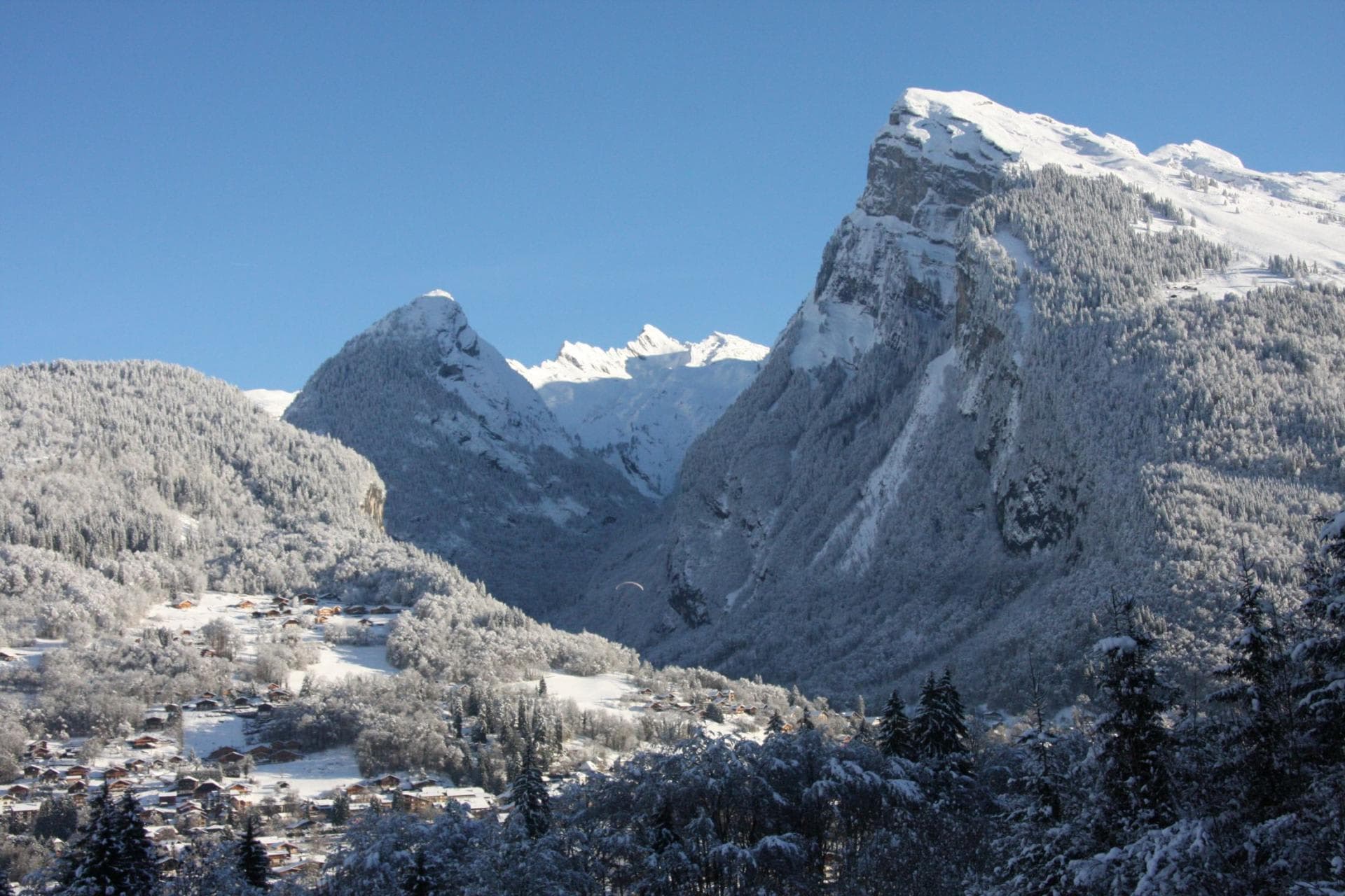 Alpine valley view overlooking snow-covered village and peaks
