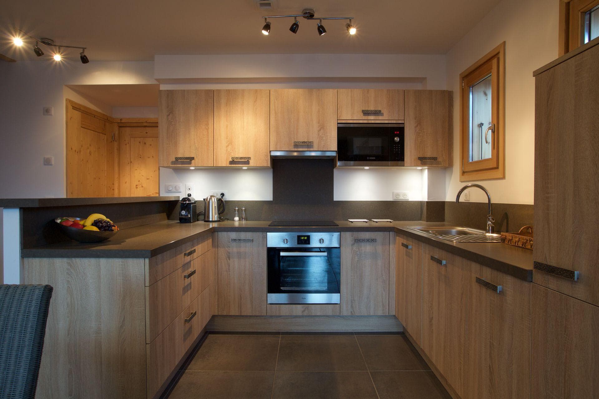 U-shaped kitchen with induction cooktop, integrated microwave, and Nespresso machine