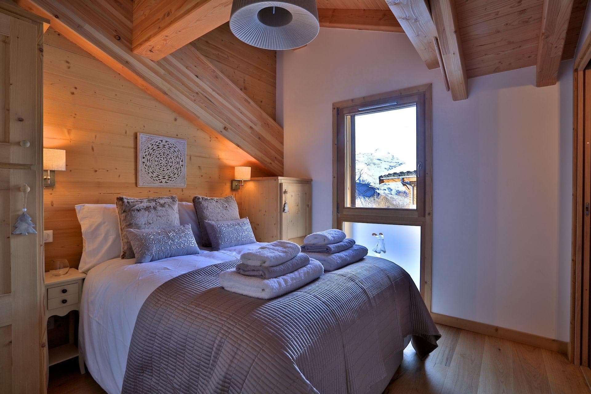 Attic bedroom with double bed and snow-capped mountain views