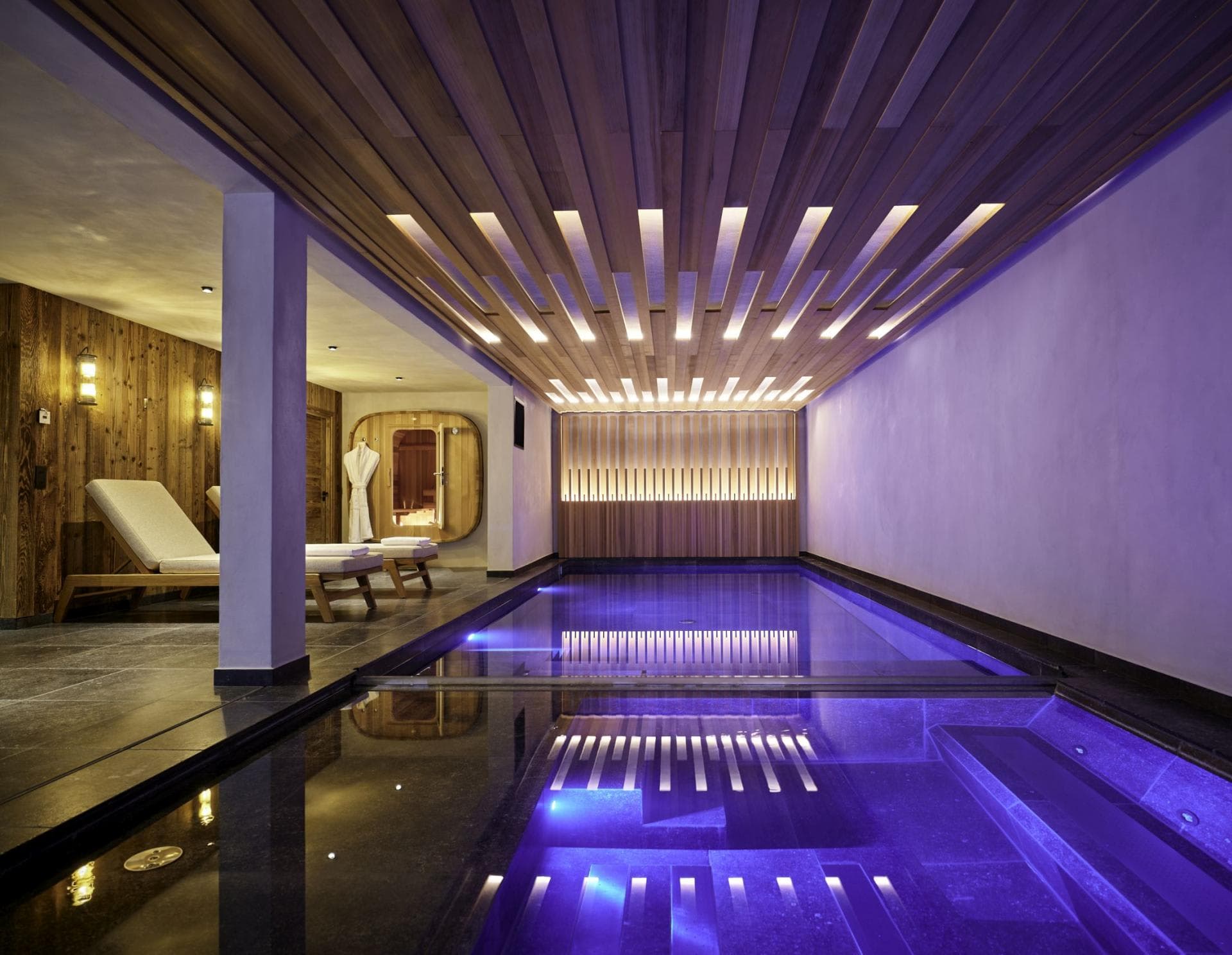 Indoor pool and spa area with loungers and private sauna