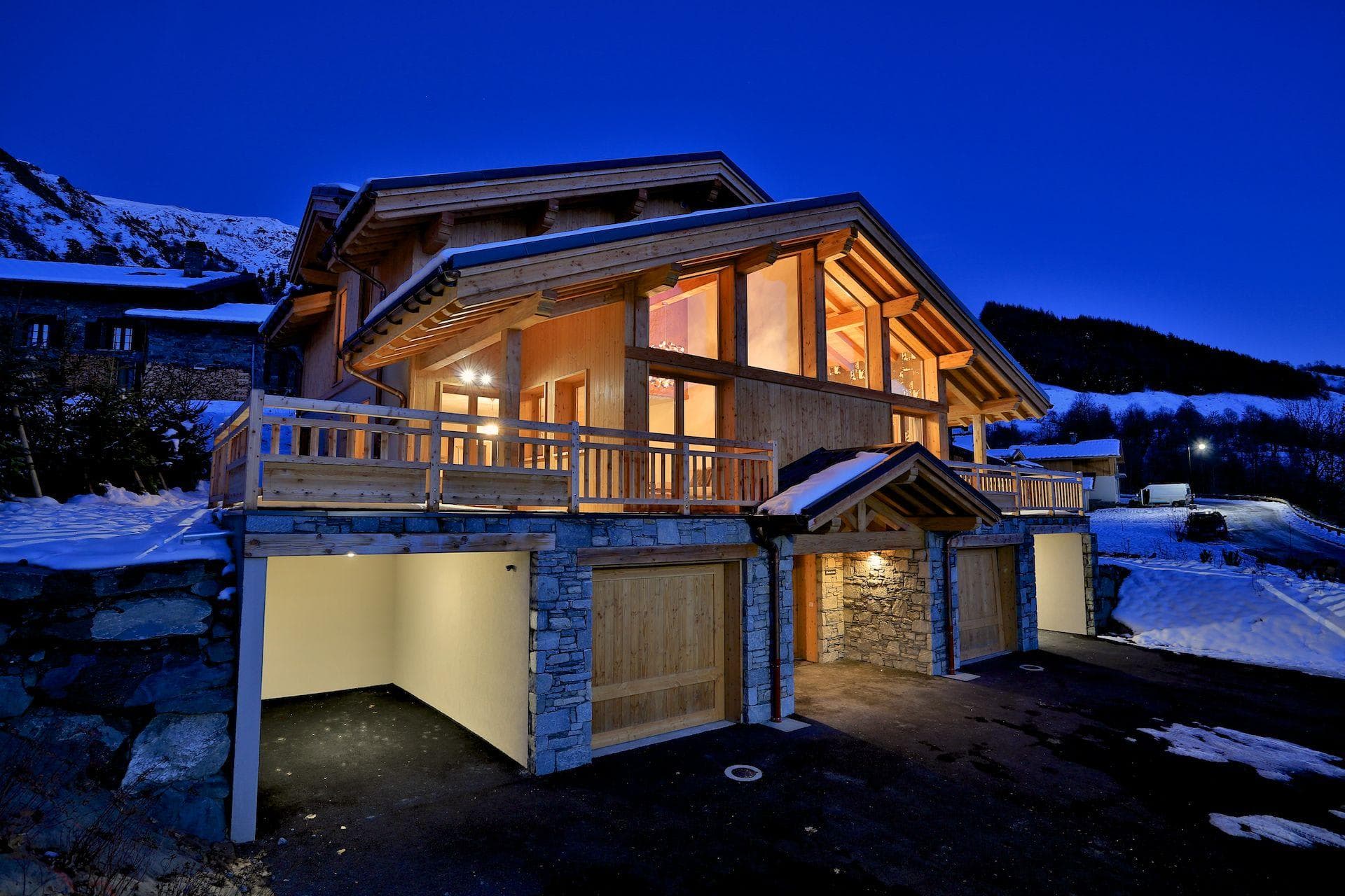 Chalet exterior with three-car garage and floor-to-ceiling windows