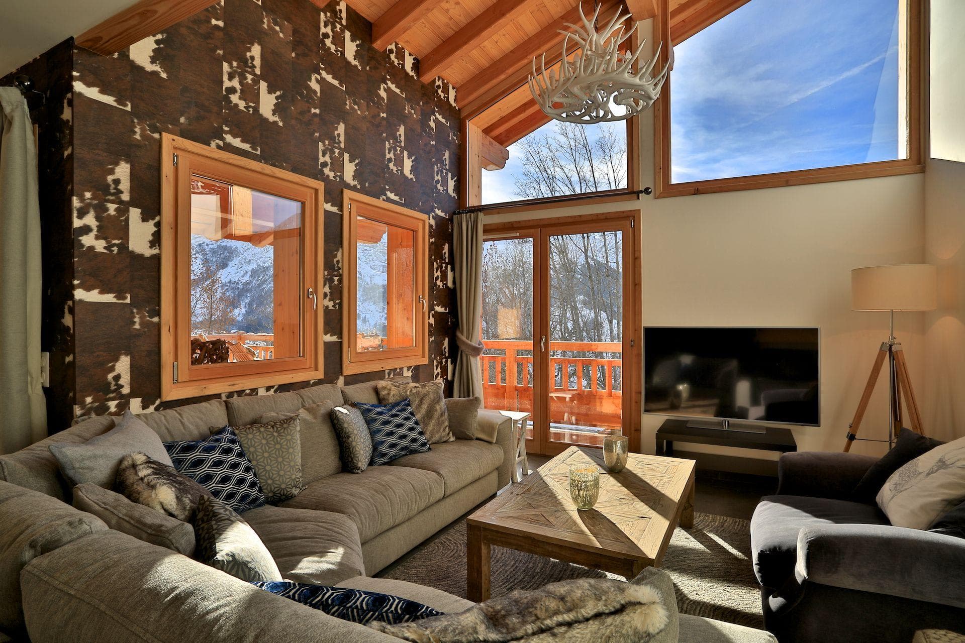 Living area with vaulted wood ceilings, sectional seating, and mountain views
