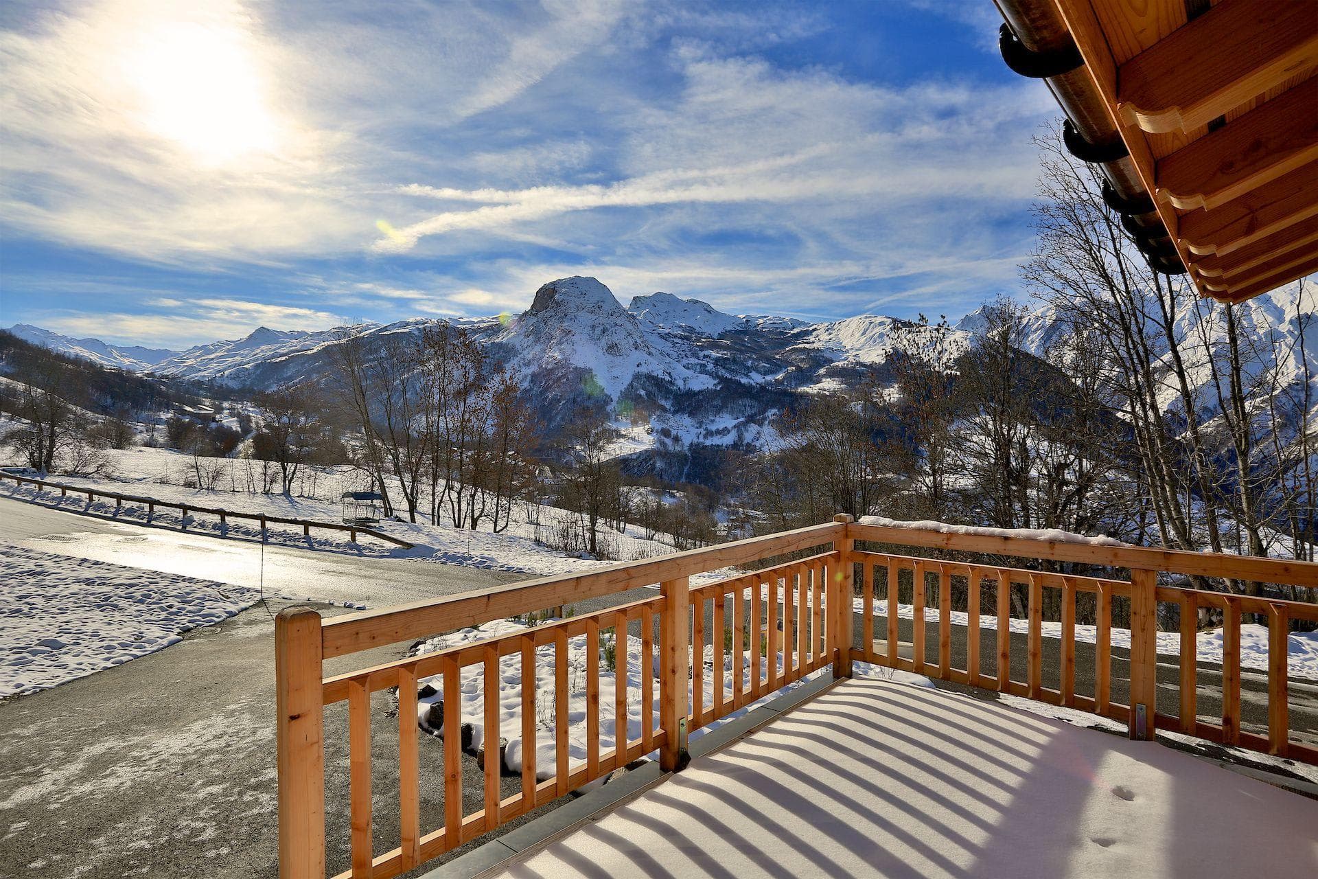 Private wooden balcony with panoramic views of snow-capped mountain peaks