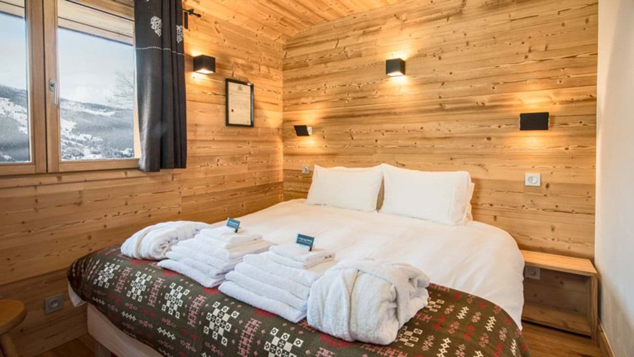 Wood-paneled bedroom with king bed and mountain valley views