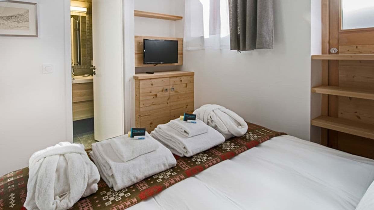 Guest bedroom with wall-mounted TV and ensuite bathroom access