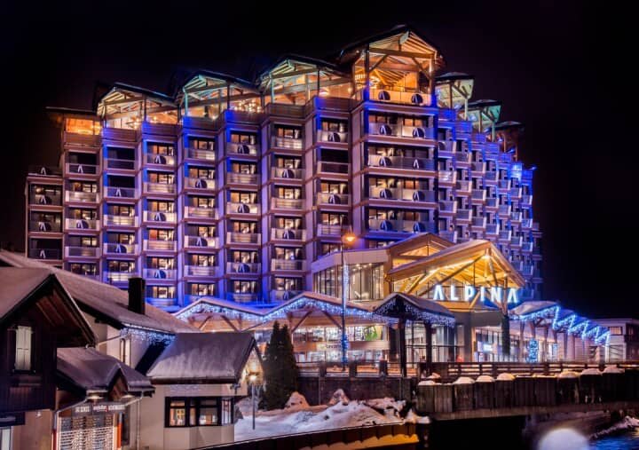 Alpina hotel exterior featuring private guest balconies and timber-framed top floor