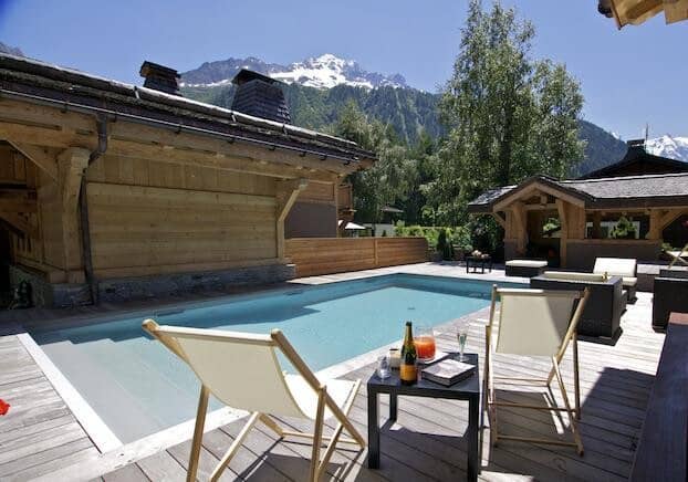 Outdoor pool and wood deck with views of snow-capped mountains