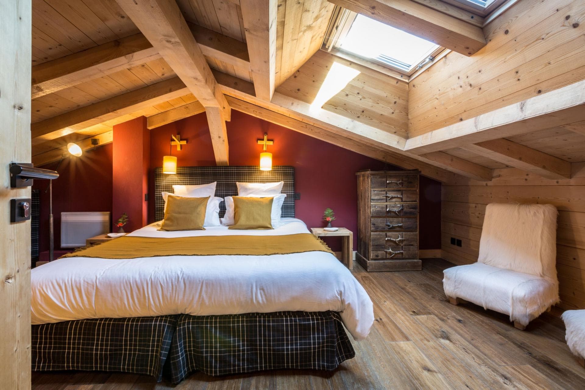 Attic bedroom with king bed and skylight over exposed timber beams