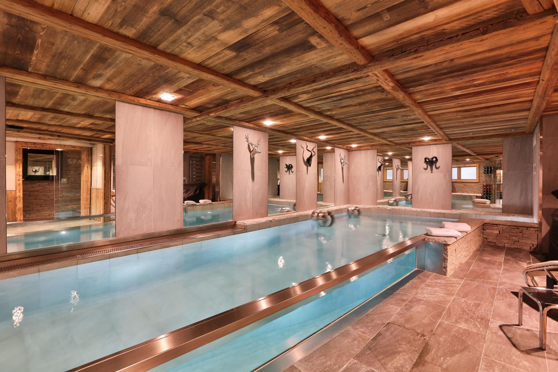 Indoor pool with glass-sided wall and wood-beamed ceiling