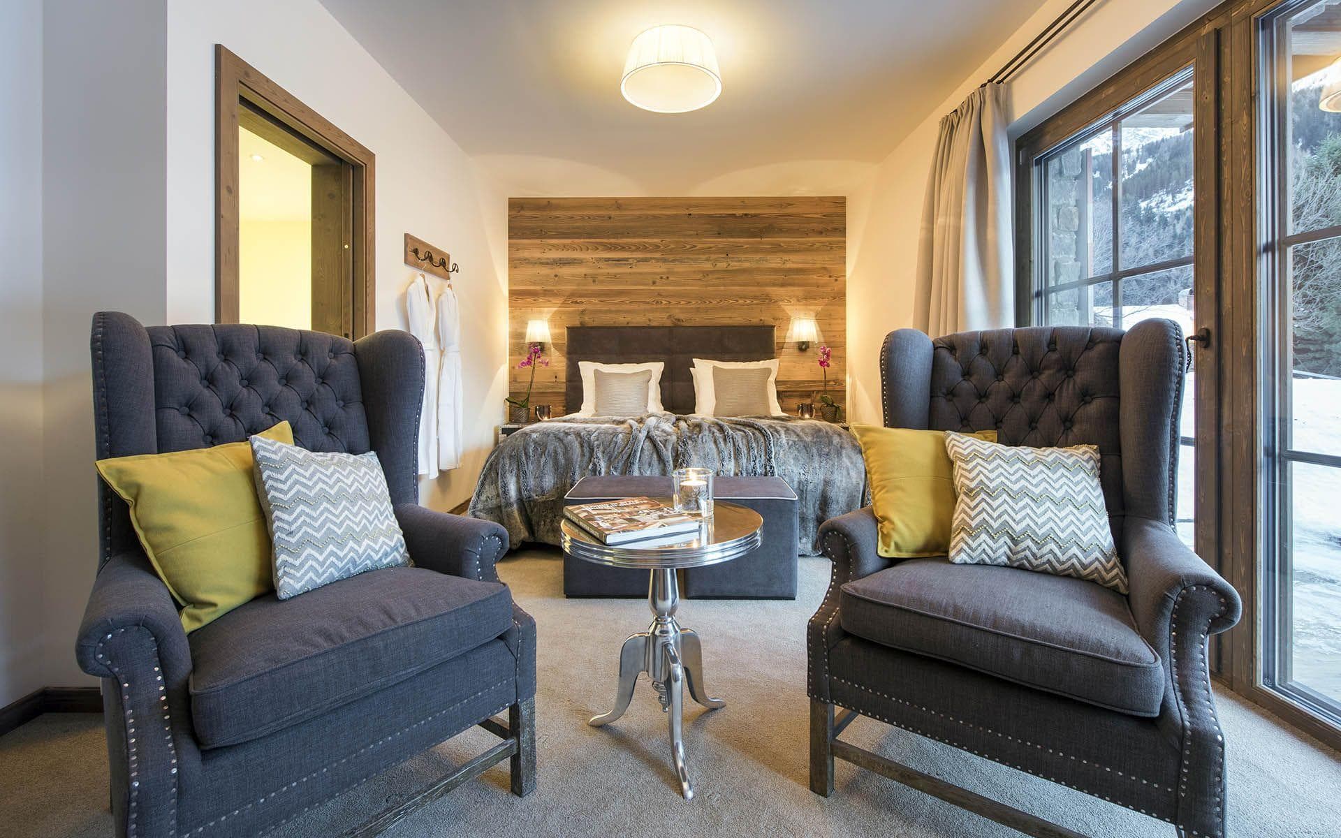 Bedroom with king bed, mountain view, and twin armchairs