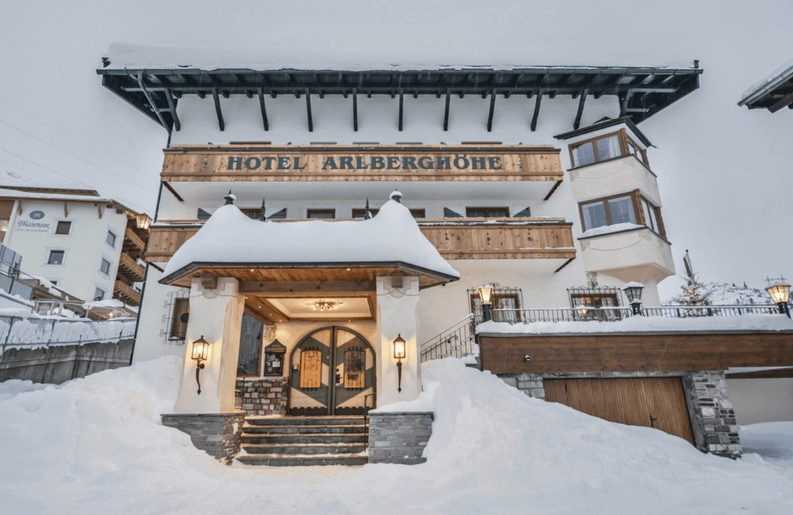 Hotel exterior with arched wooden entrance and traditional Alpine balconies