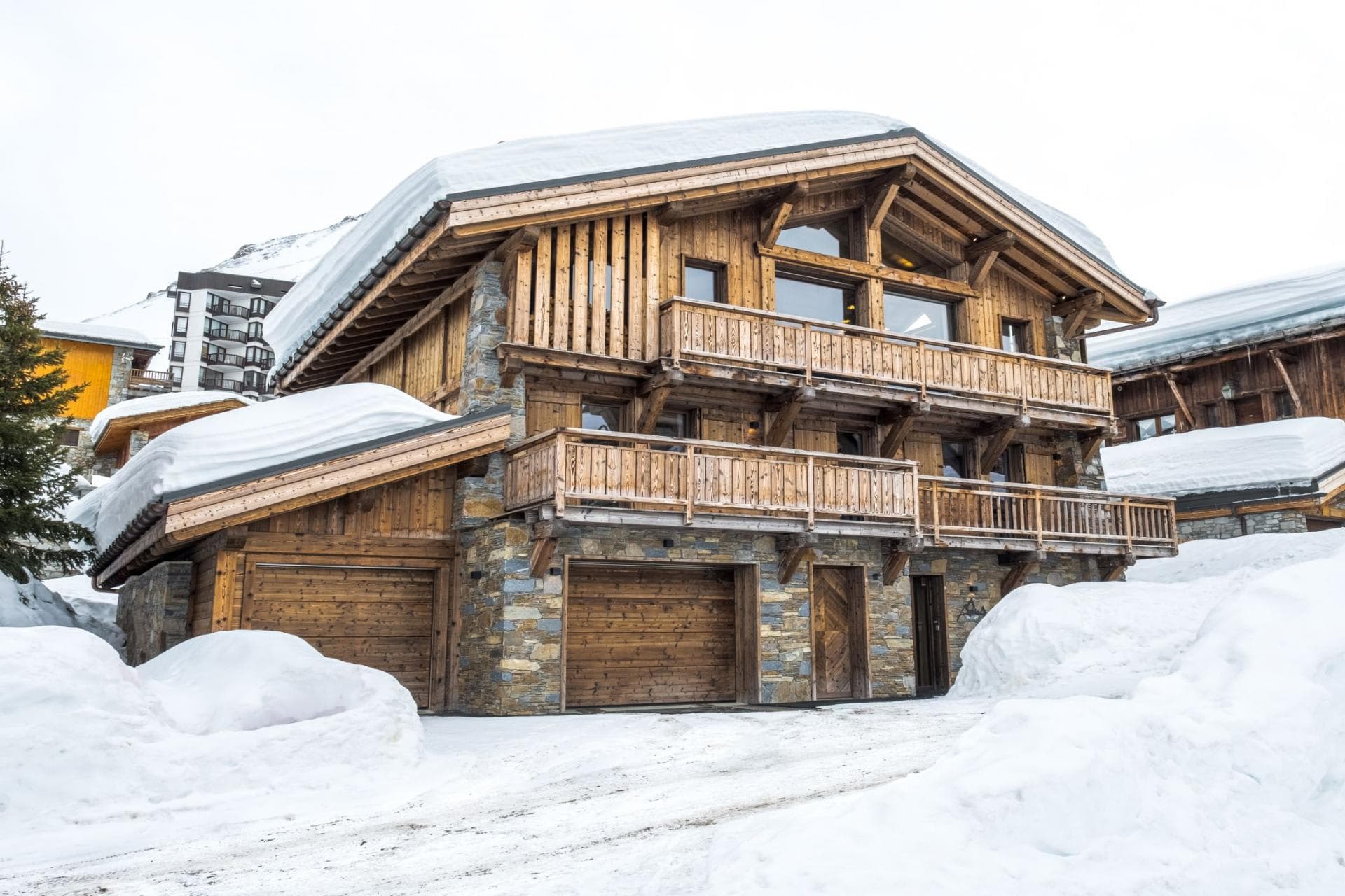 Chalet exterior with two-car garage and wraparound balconies