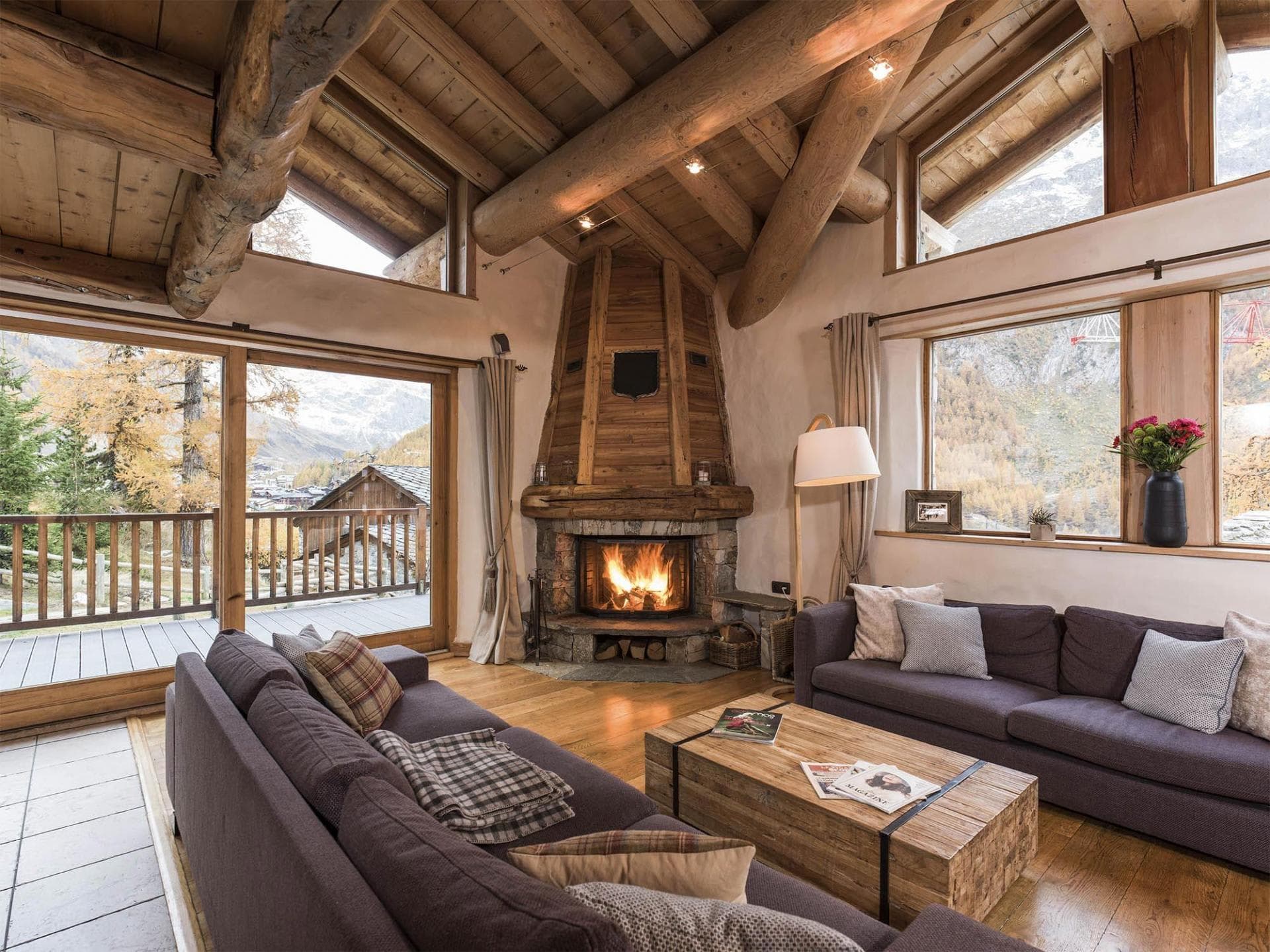Living area with wood-burning fireplace and mountain-view balcony access