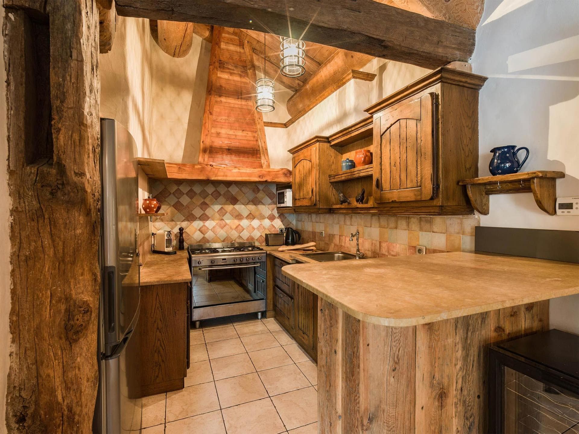 Kitchen with gas range, wine cooler, and original timber beams