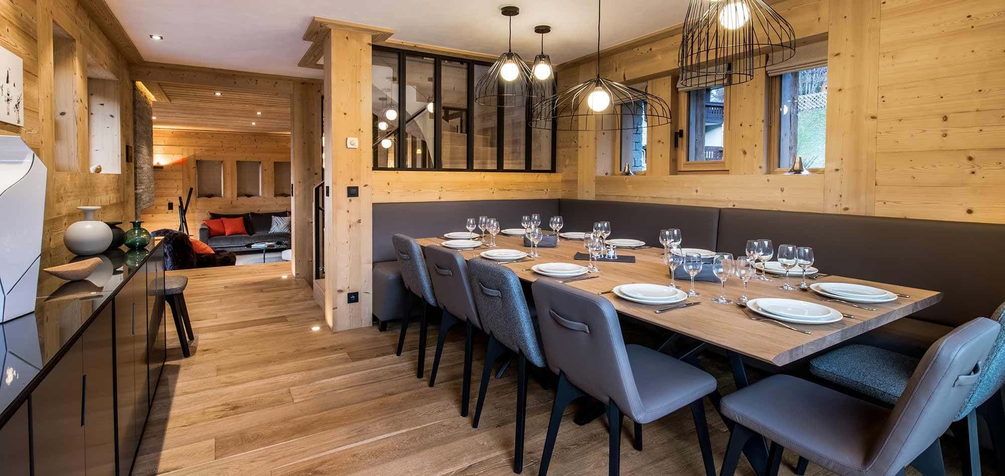 Dining area seats 10 with banquet bench and wood paneling