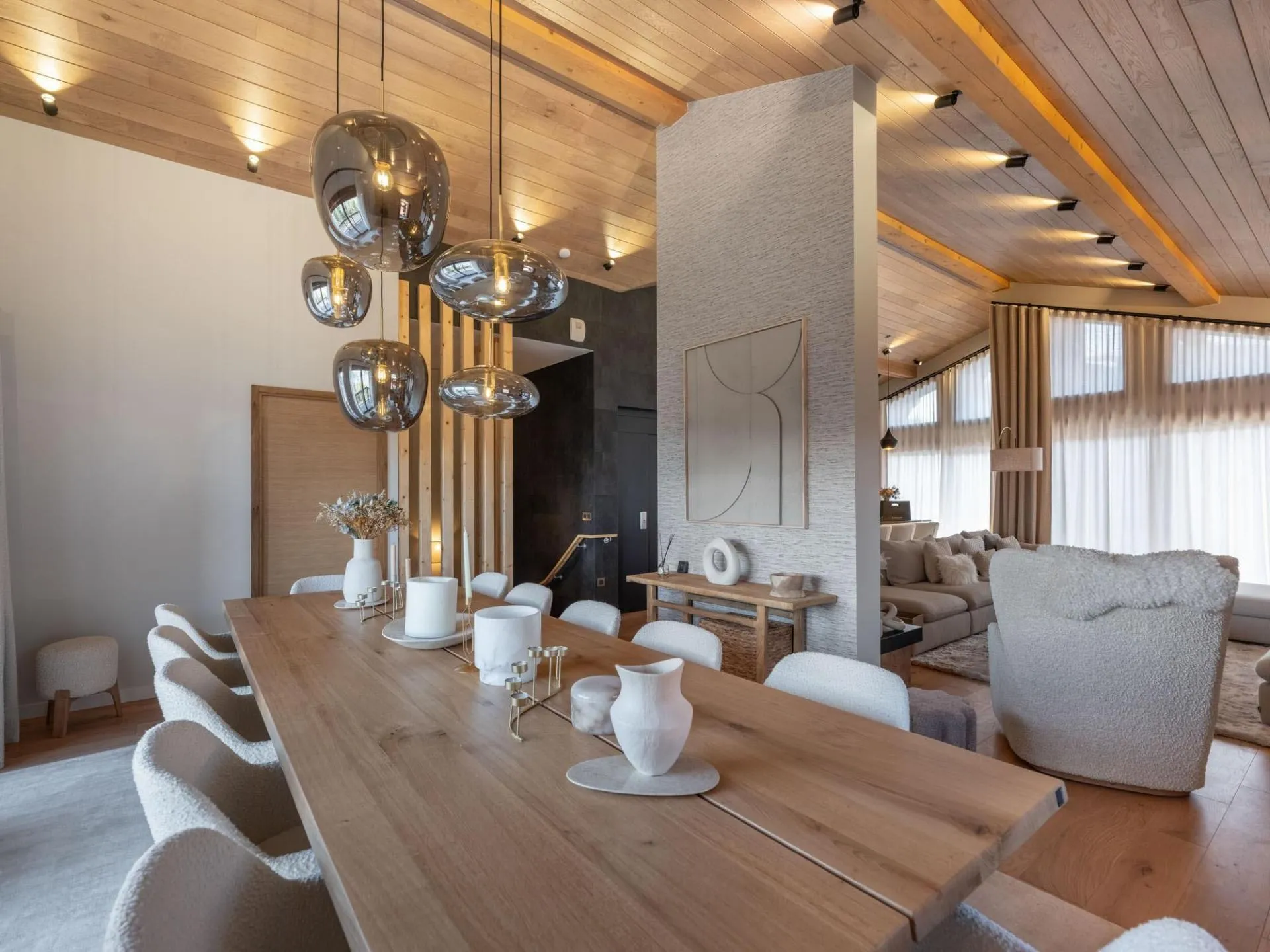 Dining table beneath pendant lights and a timber ceiling