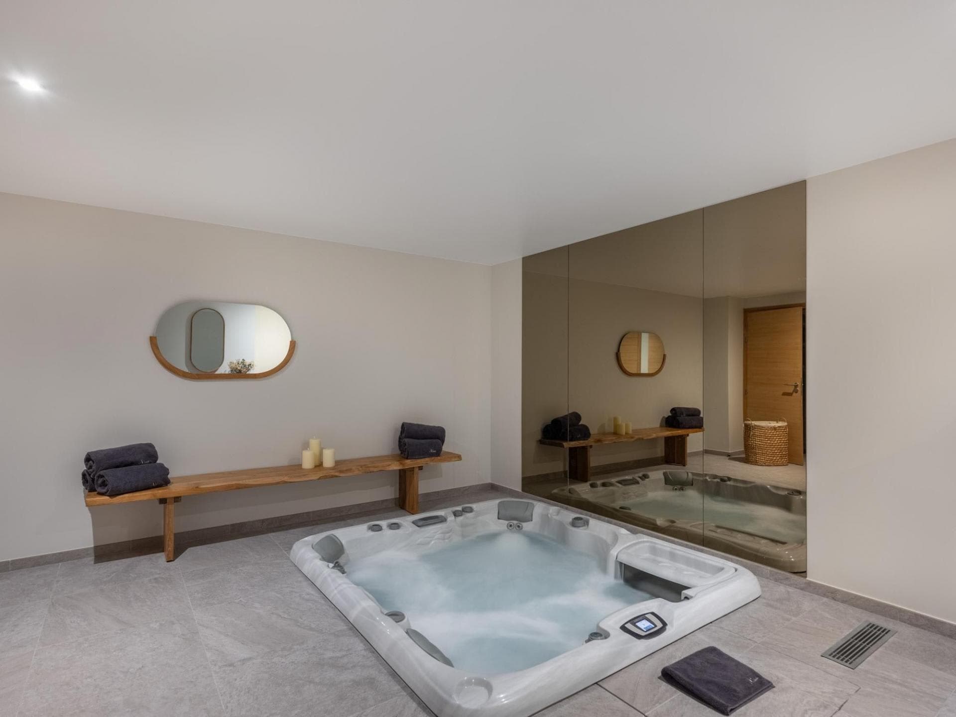 Indoor spa room with sunken hot tub and wooden bench seating