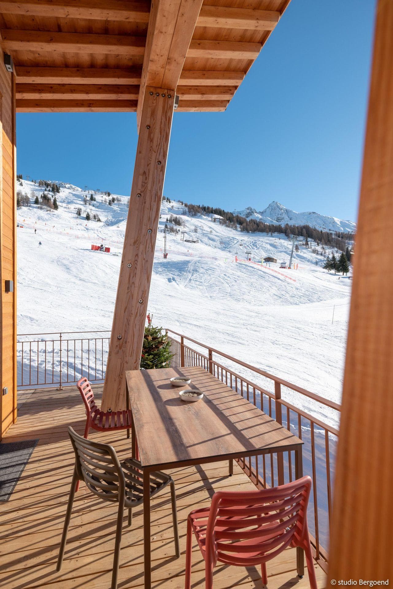 Covered balcony with dining table and direct ski-in/ski-out slope views