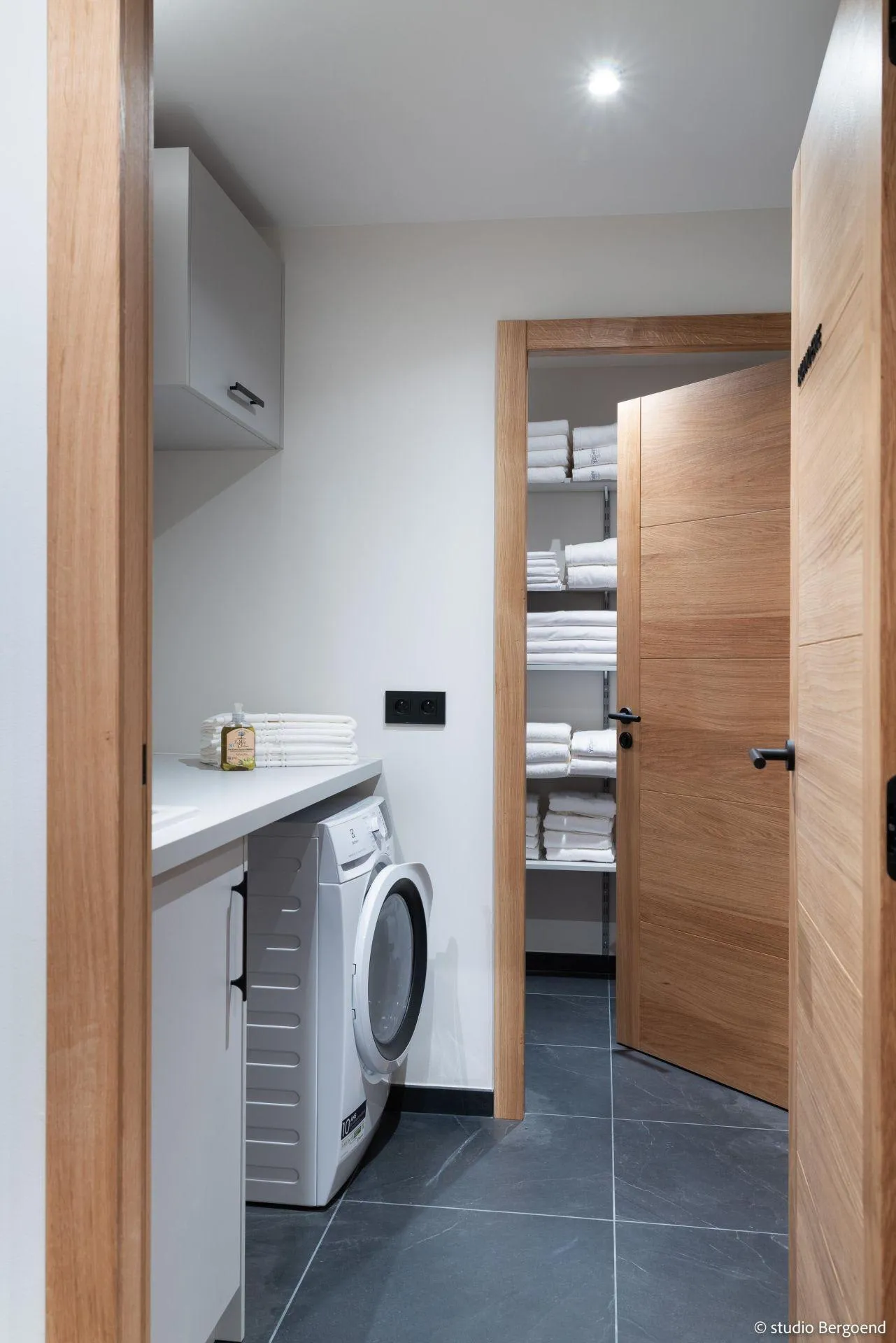 Laundry room with washer-dryer and linen storage