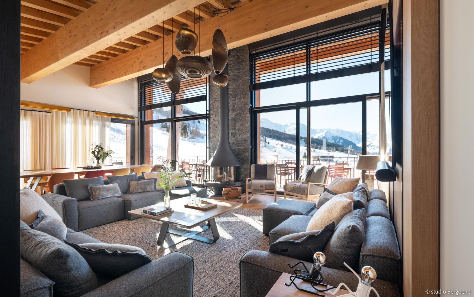 Living area with wood-burning fireplace and floor-to-ceiling mountain views
