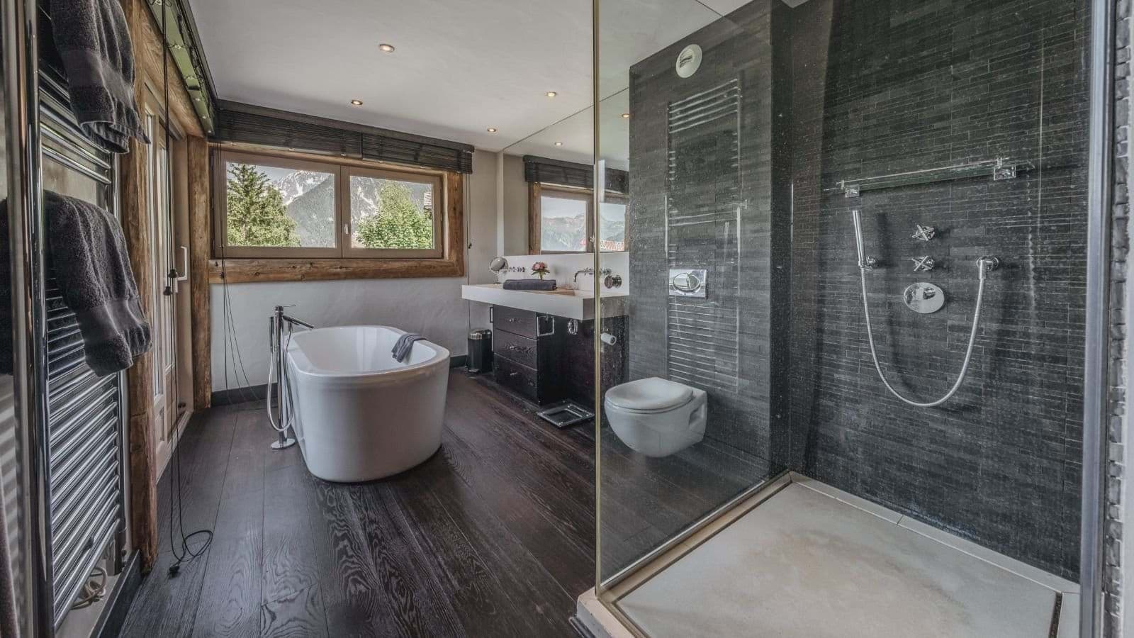 Bathroom with soaking tub, walk-in rainfall shower, and mountain views