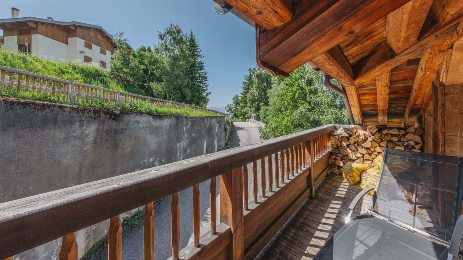 Covered timber balcony with firewood storage and armchair