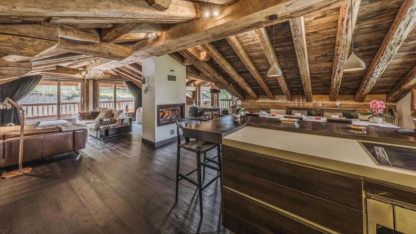 Open-plan living area with wood-burning fireplace and exposed timber beams