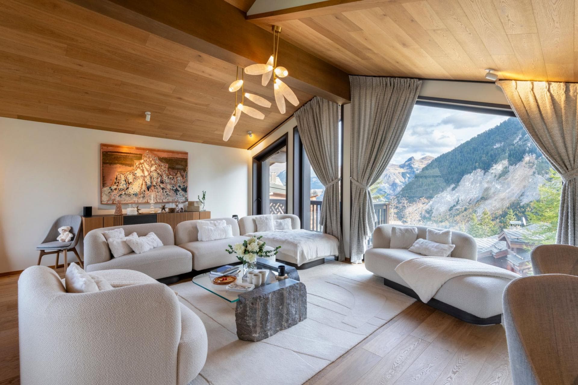 Living area with modular seating and floor-to-ceiling mountain views