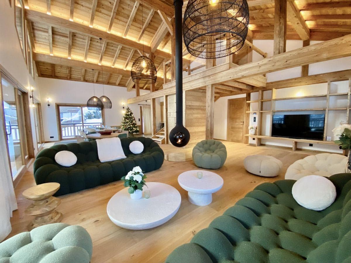 Open living area with central suspended fireplace and Roche Bobois seating