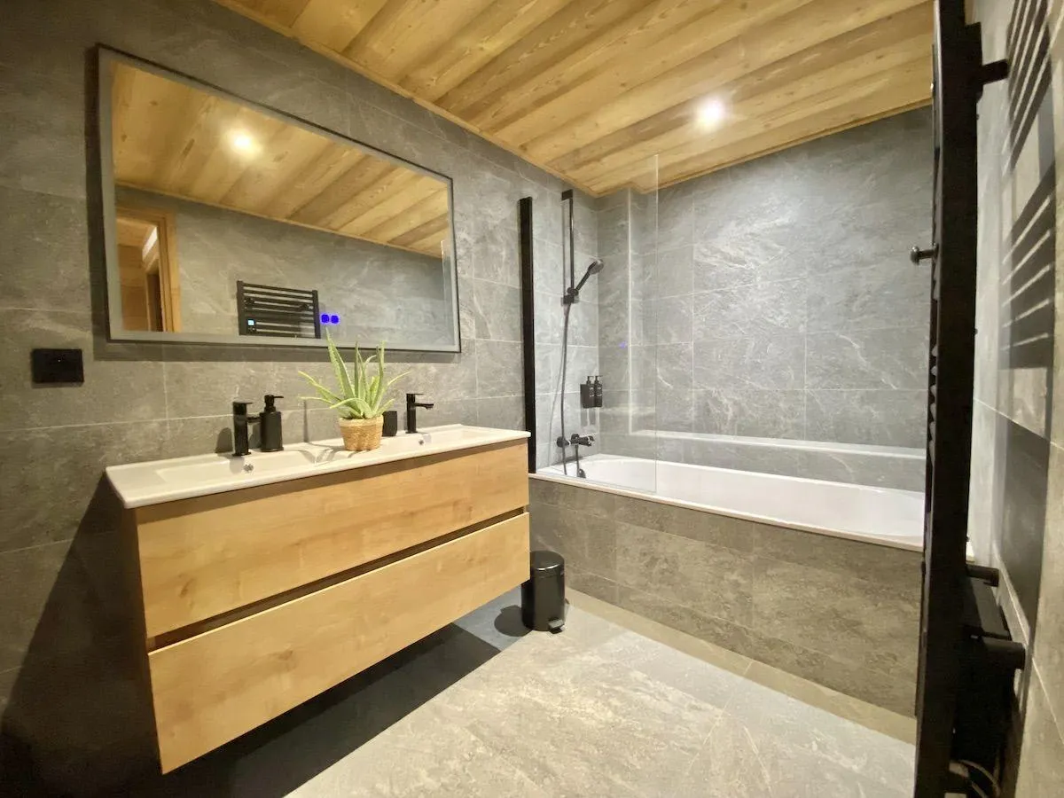 Bathroom with dual-tap vanity, heated towel rail, and soaking tub