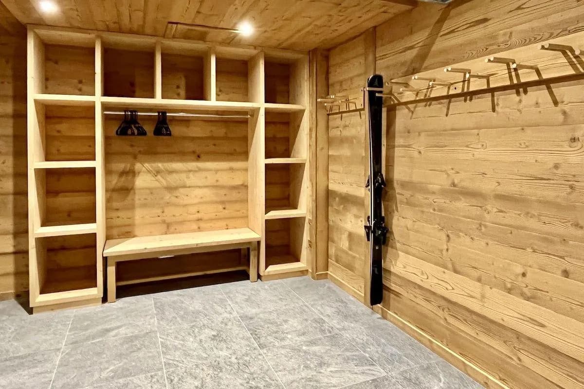 Ski room with custom shelving, bench, and wall-mounted ski racks
