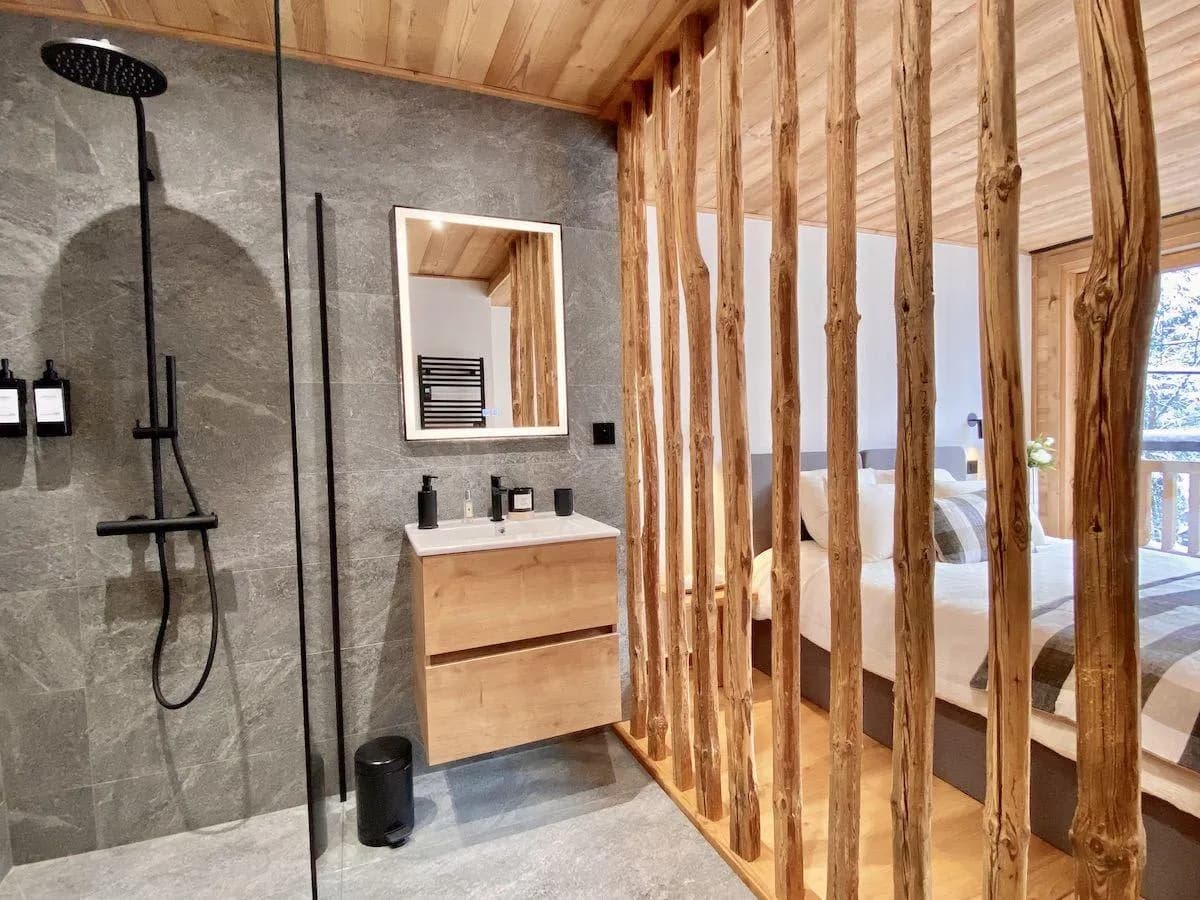 Ensuite bathroom with rainfall shower and natural wood partition to bedroom