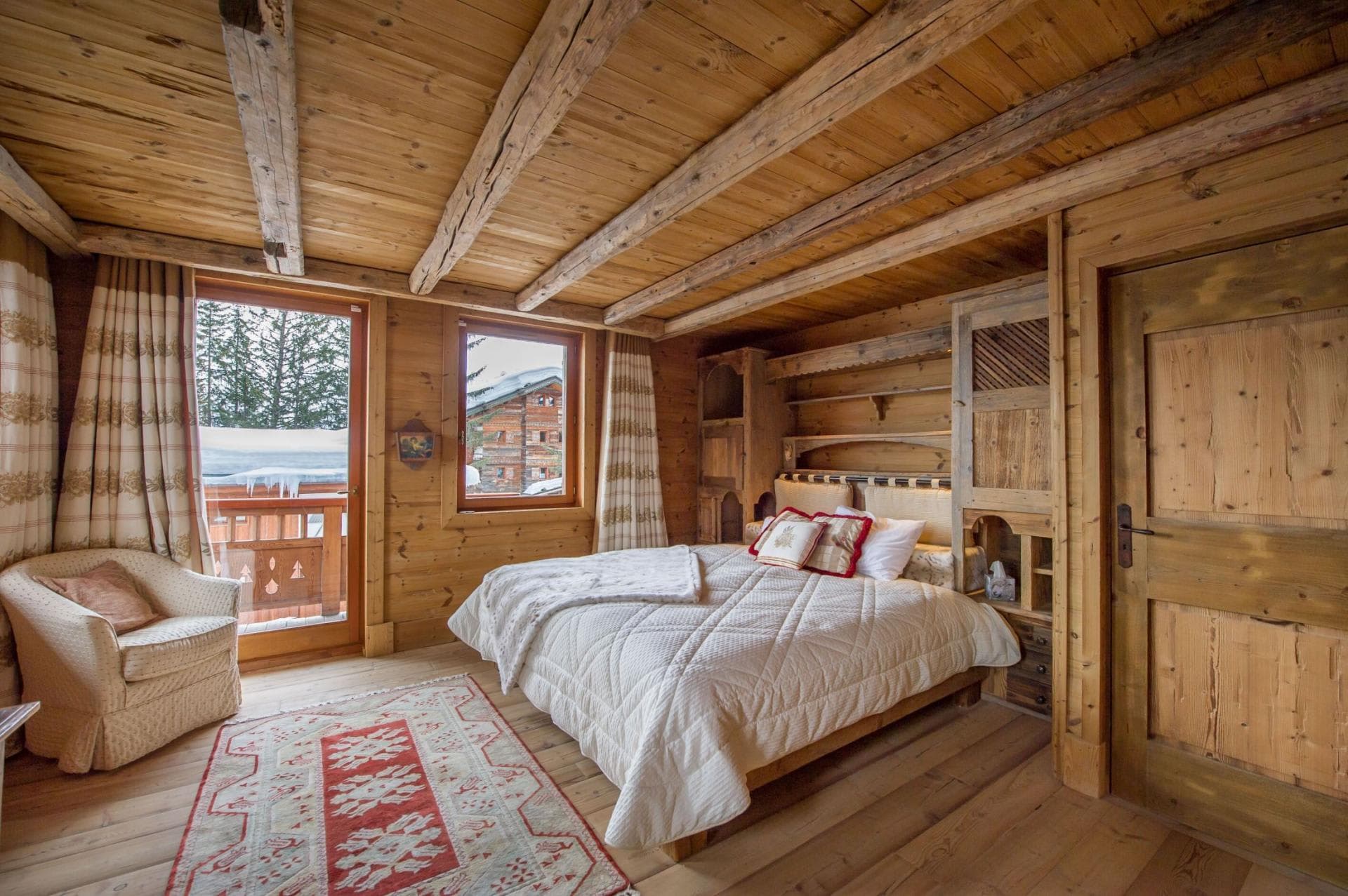 Timber-clad bedroom with king bed and private balcony access