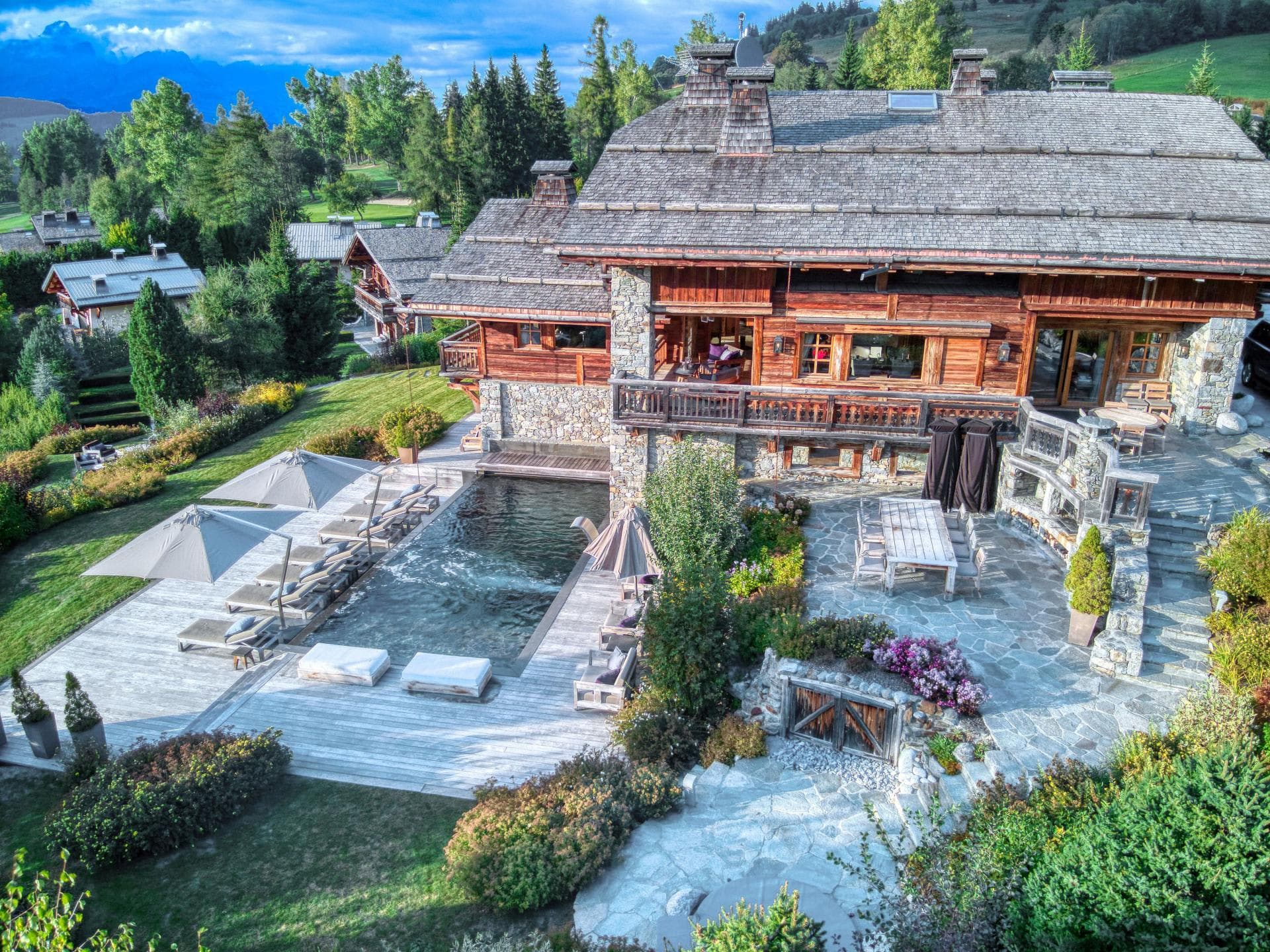 Chalet exterior with heated pool and dining terrace for 10