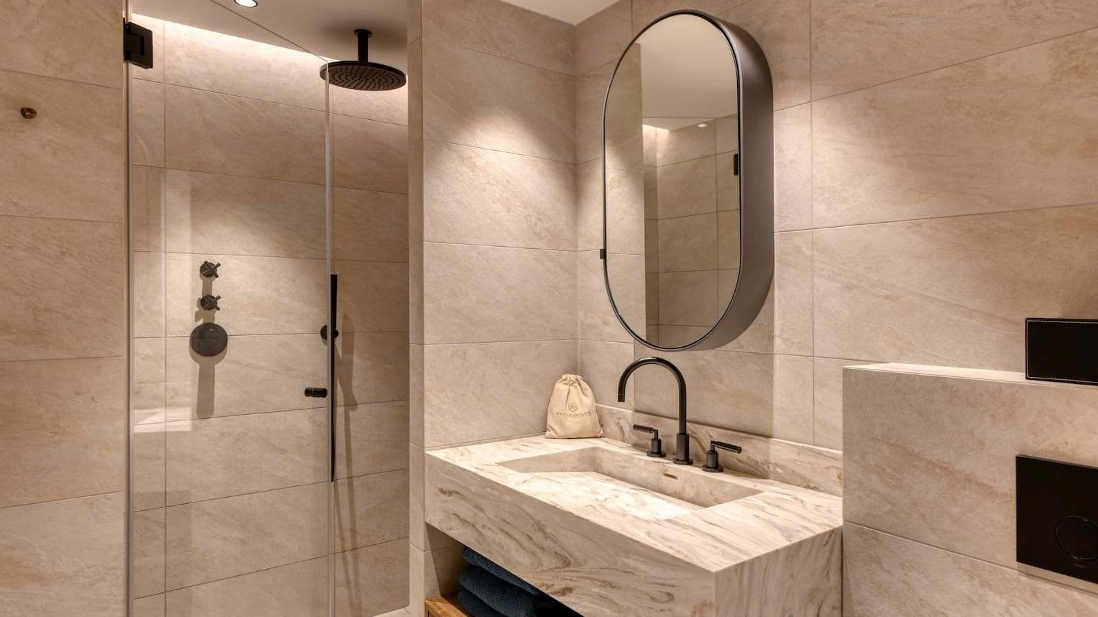 Bathroom featuring marble vanity and walk-in shower with rainfall head