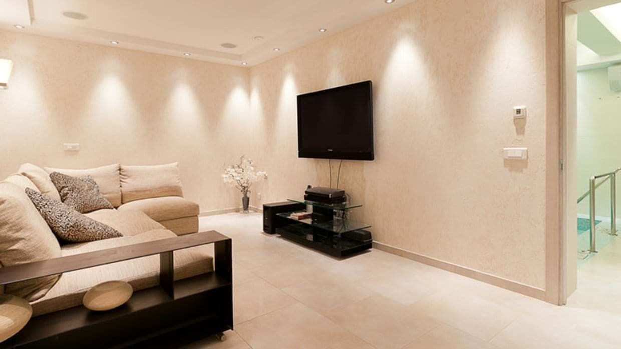 Media room with sectional seating and access to indoor pool area