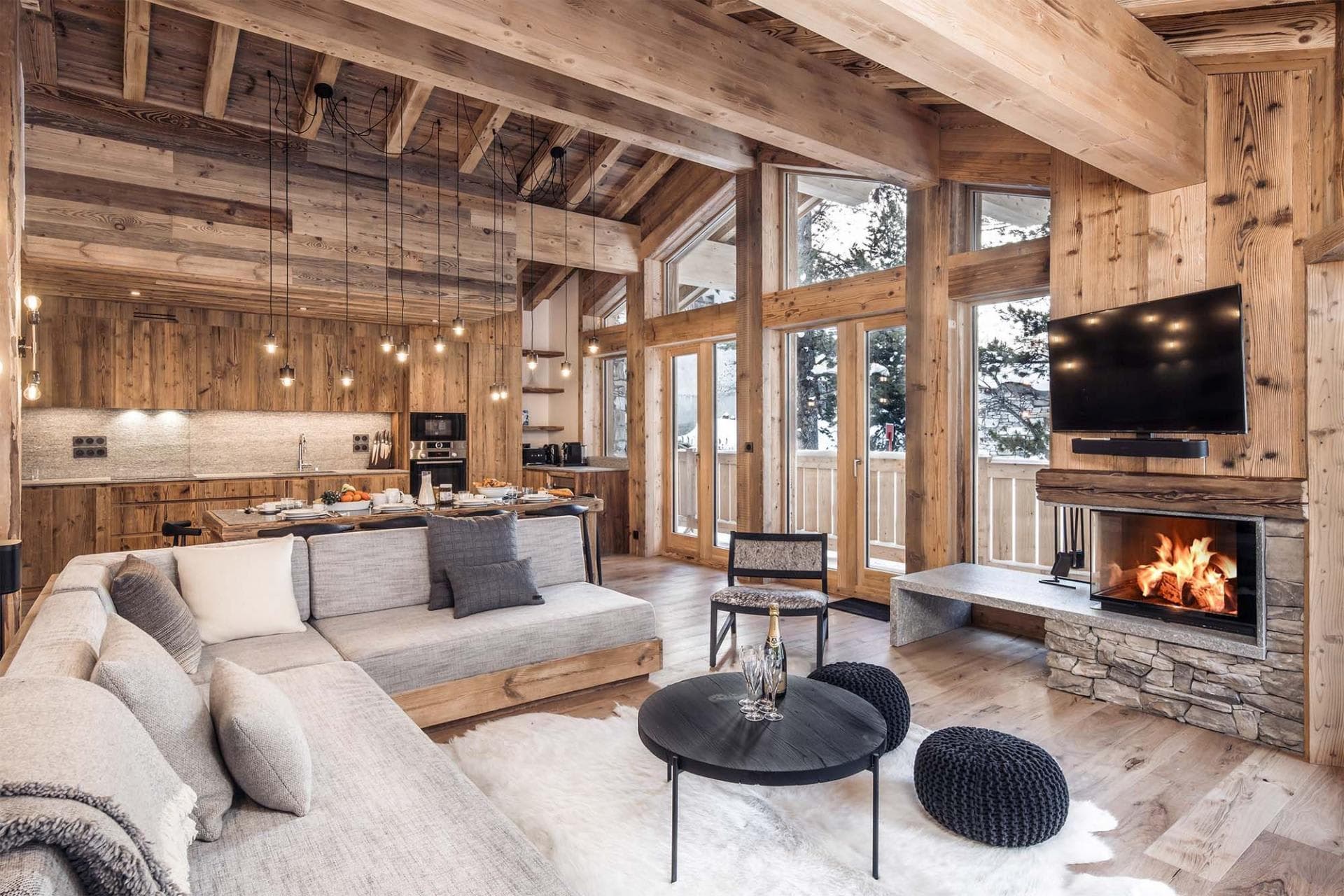 Open-plan living area with wood-burning fireplace and vaulted timber ceilings