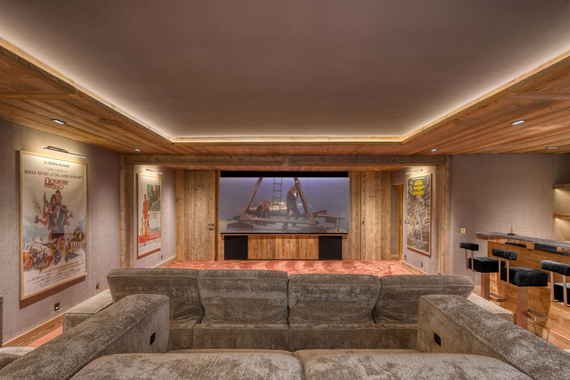 Media room with tiered sectional seating and integrated wet bar