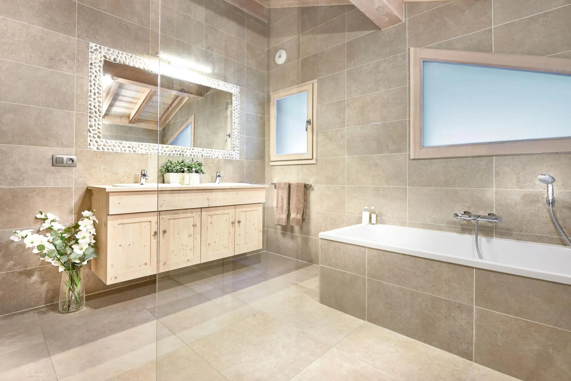 Bathroom with double vanity, soaking tub, and glass-enclosed shower area