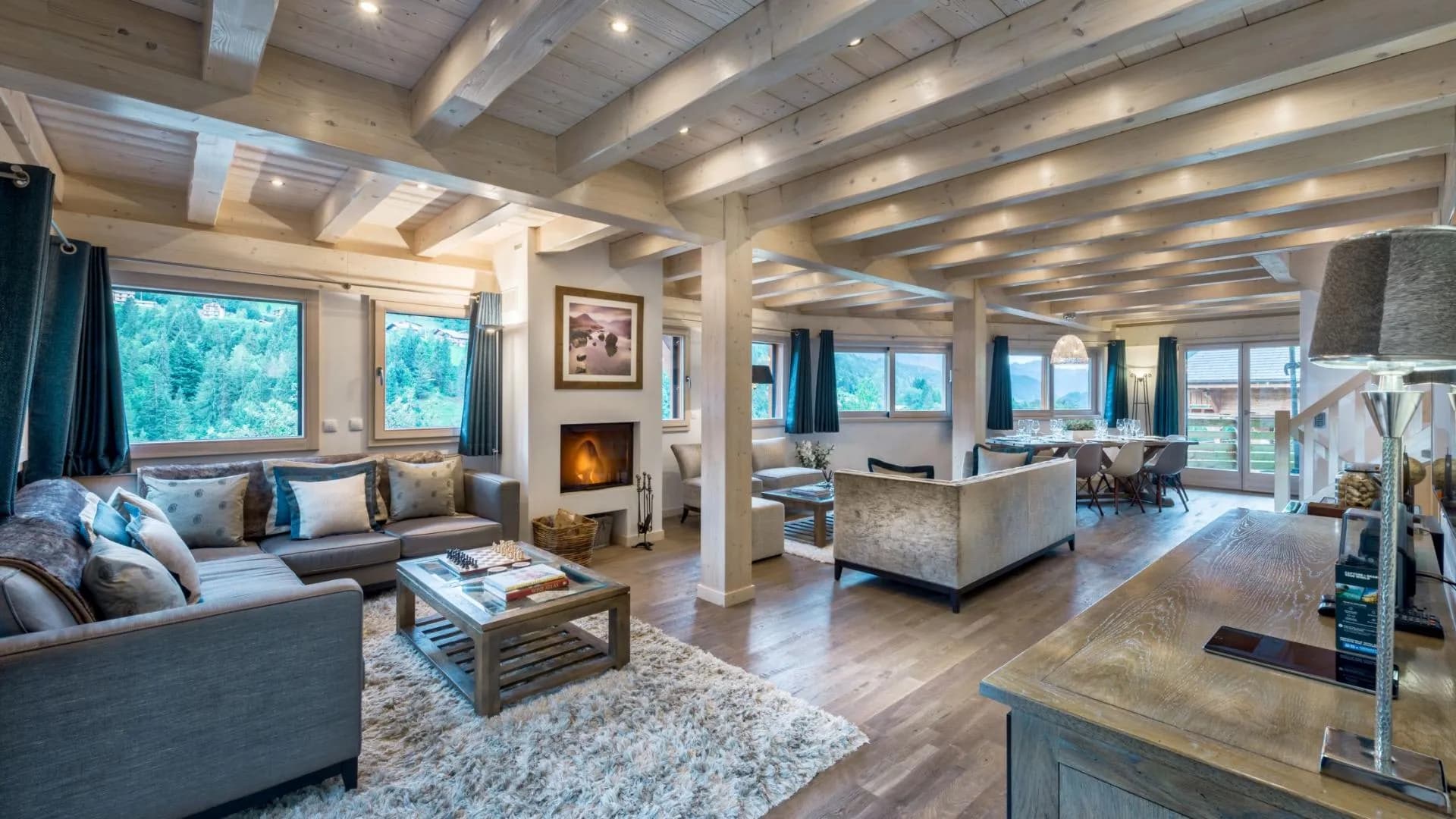 Open-plan living area with wood-burning fireplace and exposed timber beams