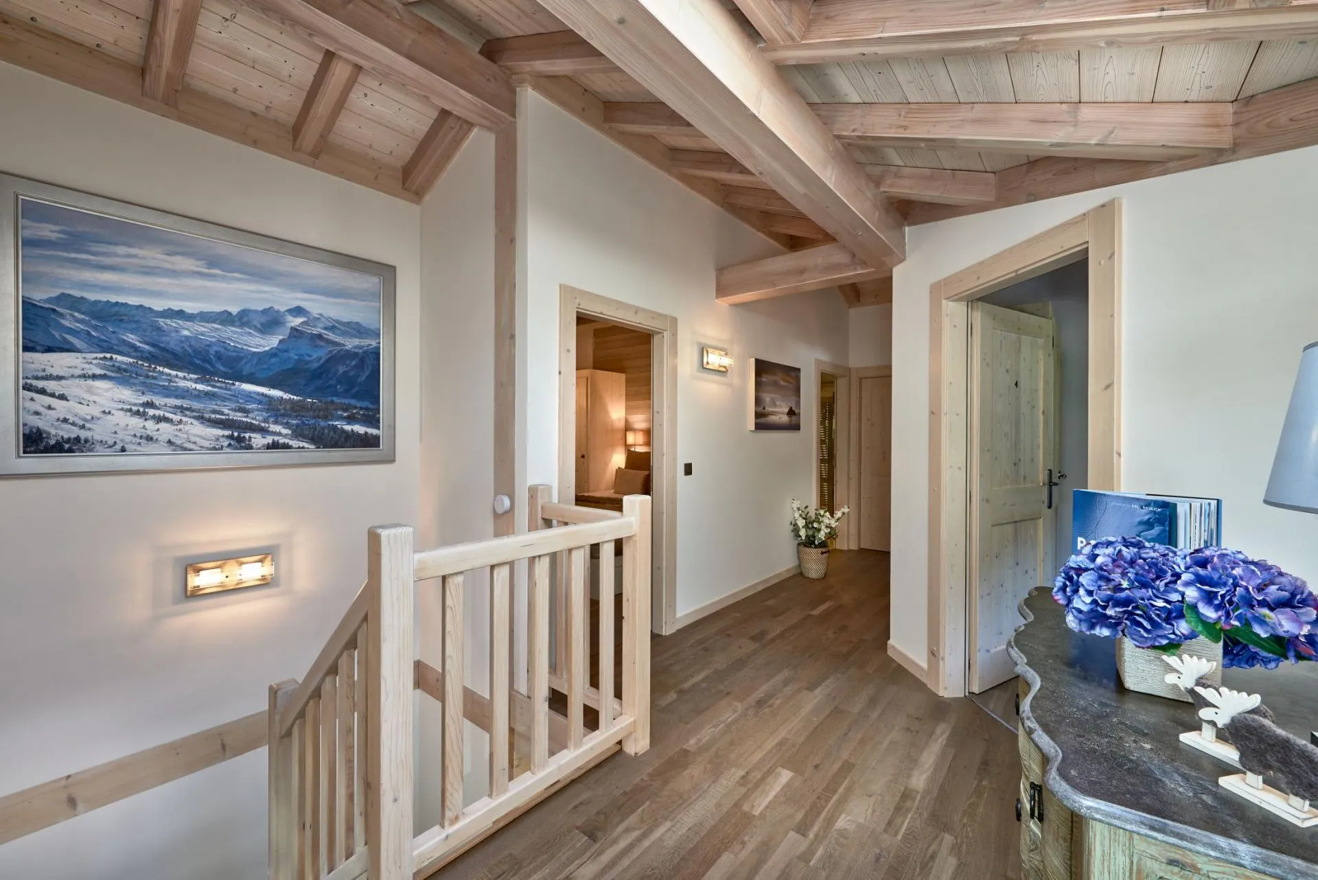 Upper floor hallway with vaulted timber ceilings and staircase access