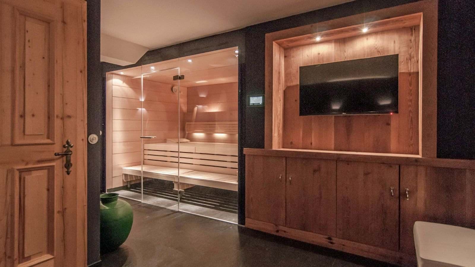 Private glass-fronted sauna with integrated TV and media console