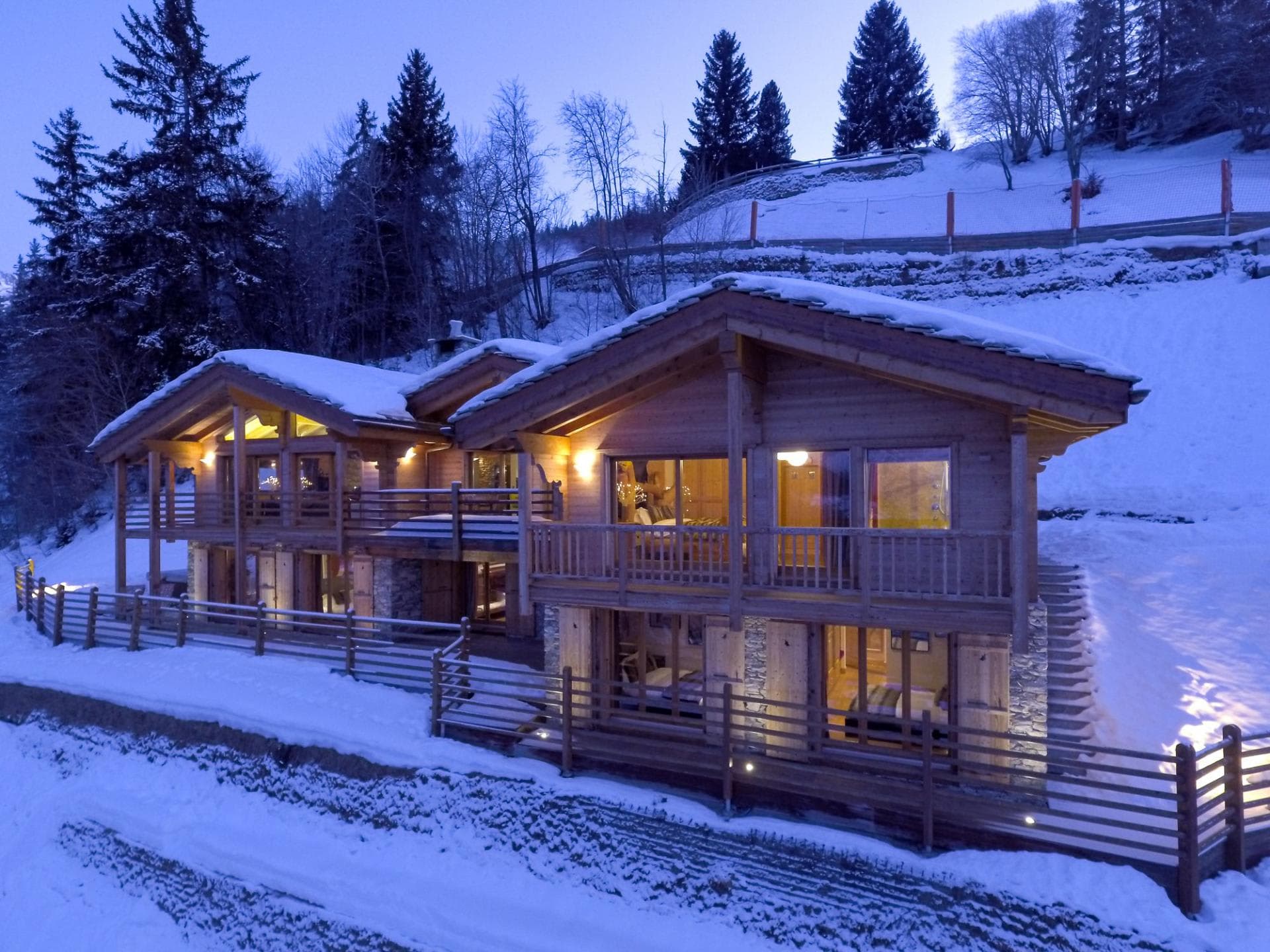 Ski-in chalet exterior with multi-level decks and snow-covered hillside