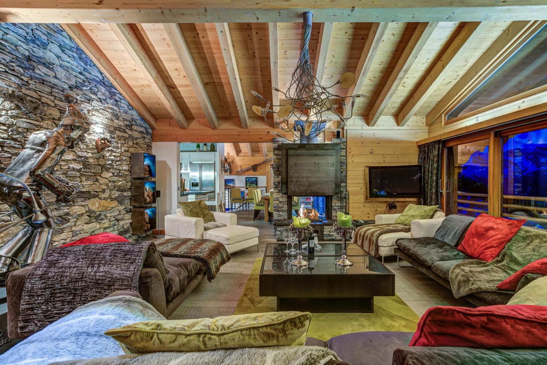 Living area with wood-burning fireplace and floor-to-ceiling mountain views