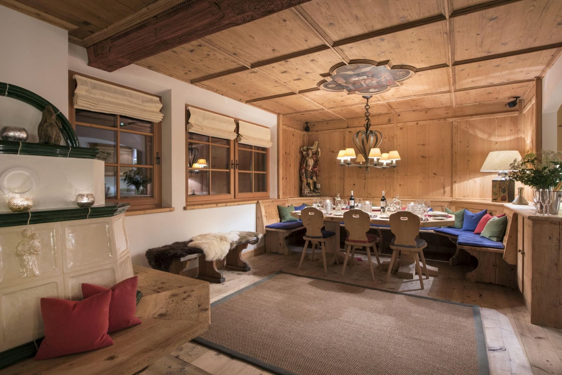 Dining area with corner bench seating for 10 and traditional masonry stove