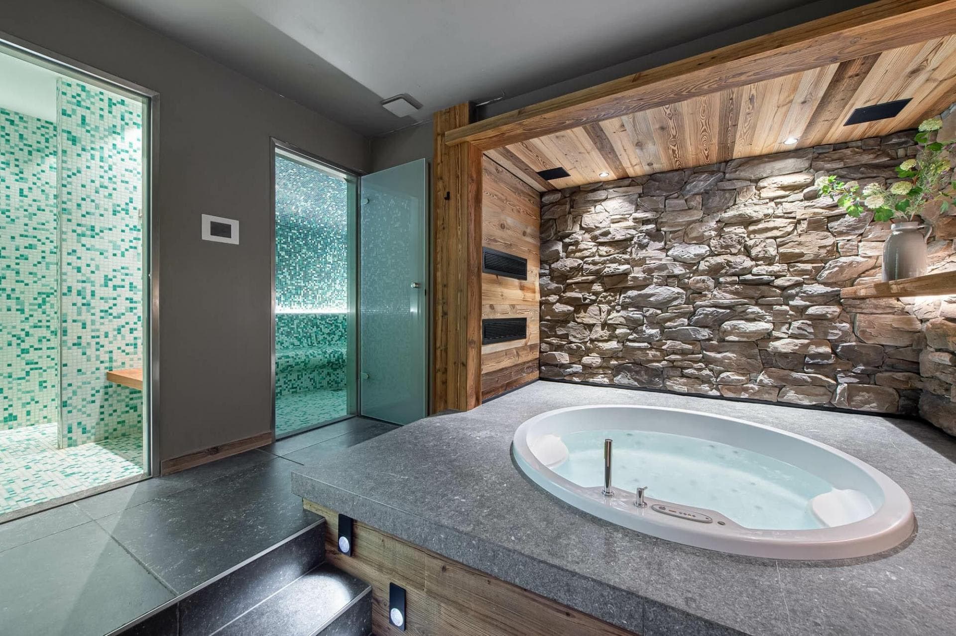 Spa room with sunken jetted tub and mosaic-tiled steam shower