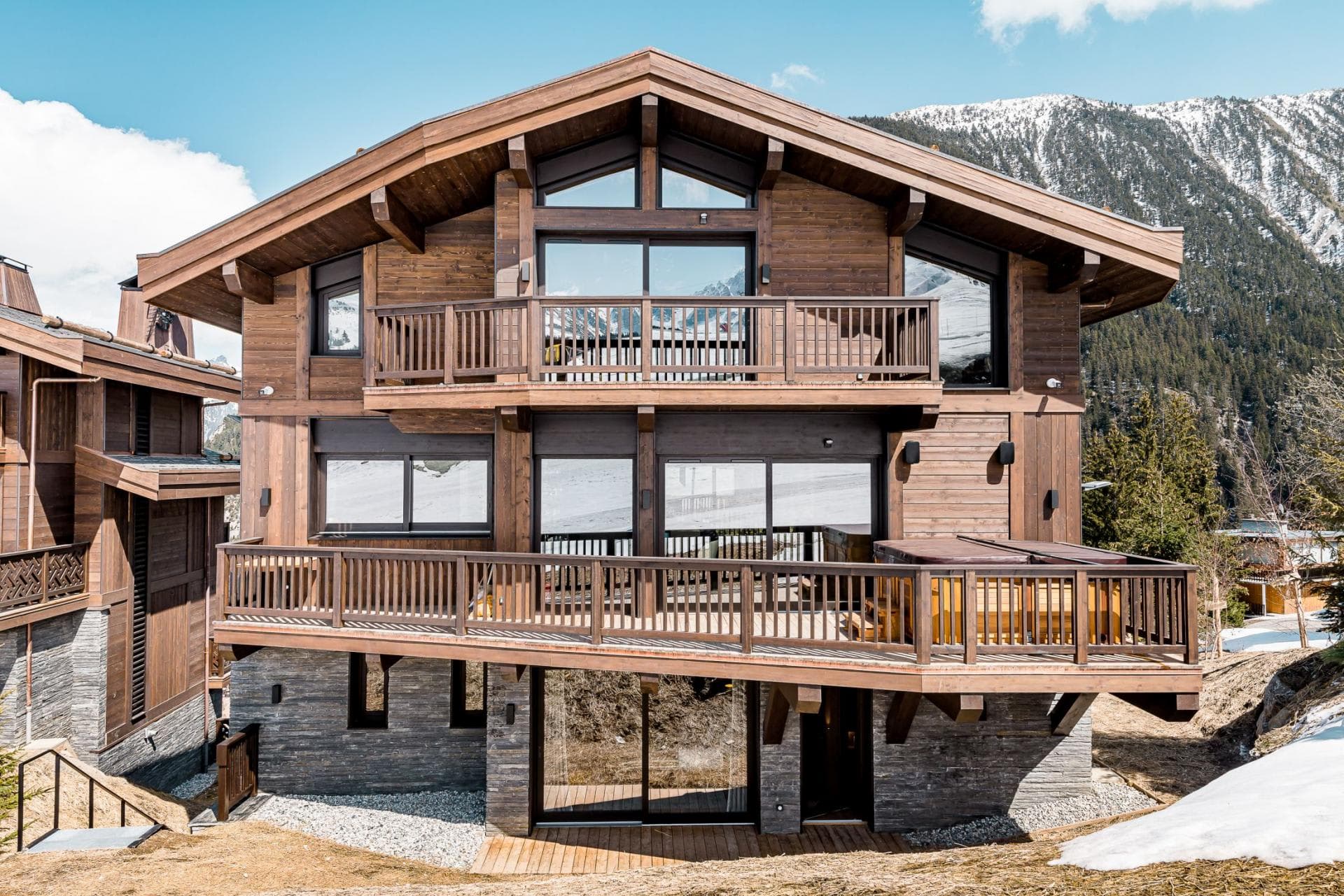 Chalet exterior with mountain-facing balconies and private hot tub