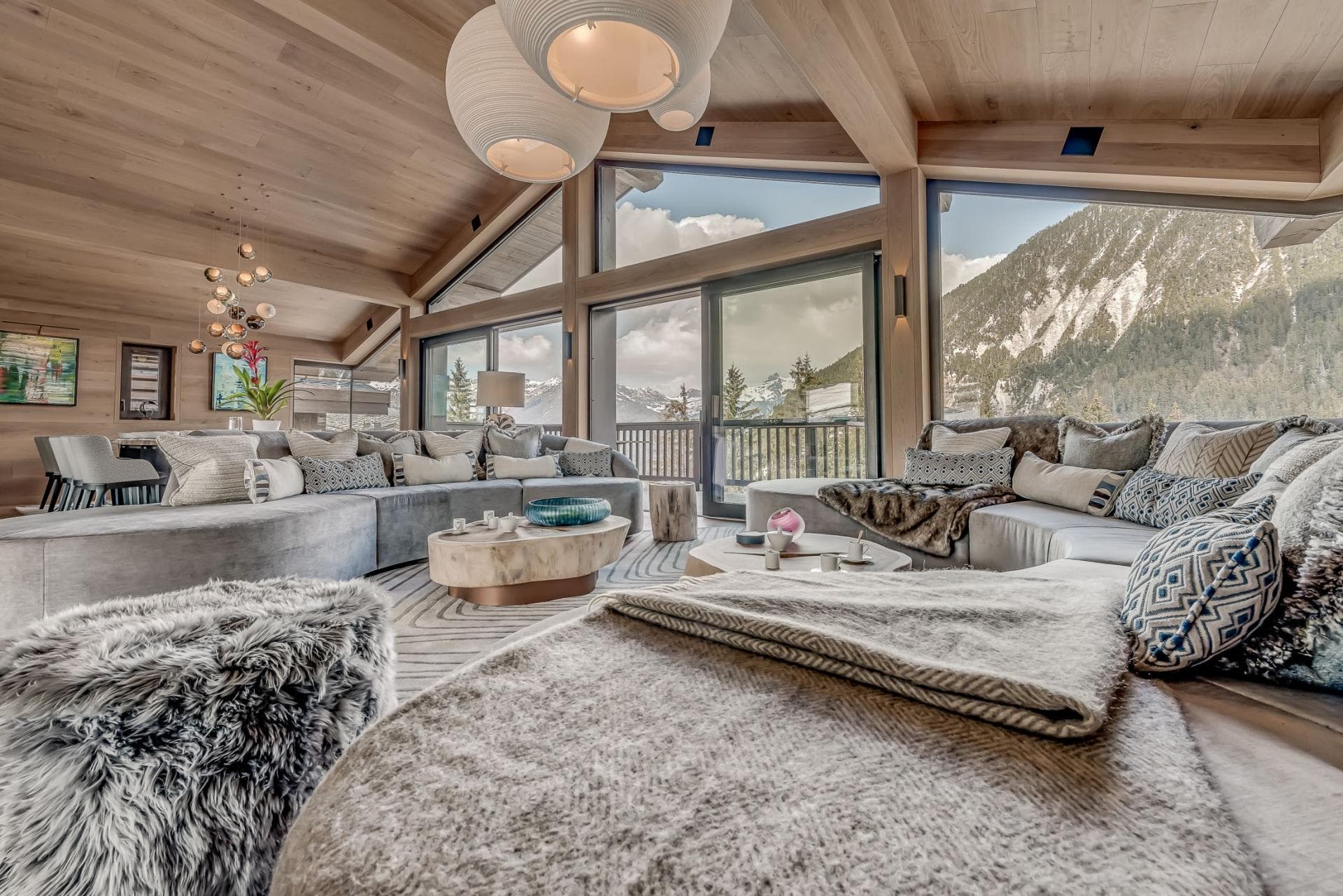 Living area with floor-to-ceiling mountain views and oversized sectional seating