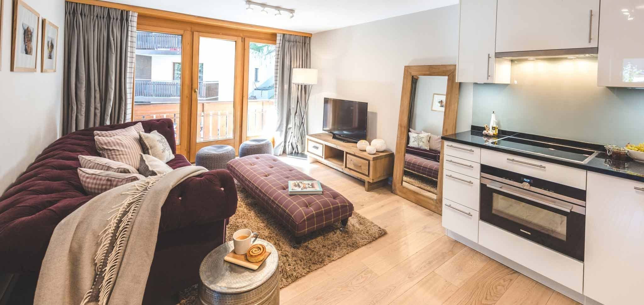 Open-plan living area and kitchenette with induction cooktop and balcony access